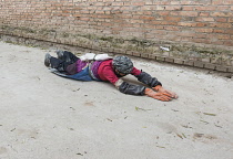 China, Tibet, Pilgrim doing kora by performing full body prostrations near Longwu monastery.