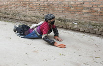 China, Tibet, Pilgrim doing kora by performing full body prostrations near Longwu monastery.