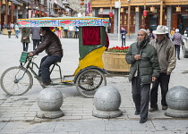 China, Sichuan, Songpan, Yawning trishaw driver and walking aged citizens.