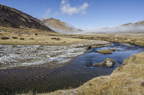 China, Tibet, Beautiful view of a Tibetan river flowing through a highland yaks pasture