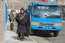 China, Tibet, Qingzhenxiang, Smiling Tibetan in the national clothes at the street of high altitude city.