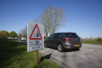 Transport, Road, Cars, resurfaced road with sign warning of reduced speed limit and loose chippings.
