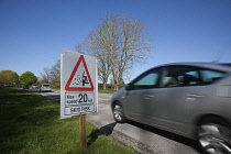 Transport, Road, Cars, resurfaced road with sign warning of reduced speed limit and loose chippings.