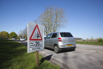 Transport, Road, Cars, resurfaced road with sign warning of reduced speed limit and loose chippings.