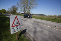 Transport, Road, Cars, resurfaced road with sign warning of reduced speed limit and loose chippings.