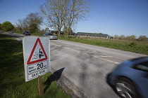 Transport, Road, Cars, resurfaced road with sign warning of reduced speed limit and loose chippings.