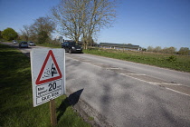 Transport, Road, Cars, resurfaced road with sign warning of reduced speed limit and loose chippings.