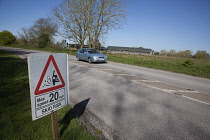 Transport, Road, Cars, resurfaced road with sign warning of reduced speed limit and loose chippings.