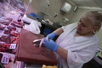 Spain, Castilla La Mancha, Toldeo, Butcher preparing meat for display.