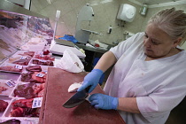Spain, Castilla La Mancha, Toldeo, Butcher preparing meat for display.