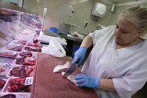 Spain, Castilla La Mancha, Toldeo, Butcher preparing meat for display.