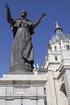 Spain, Madrid, Cathedral de la Almudena with statue of Pope John Paul II in the courtyard.