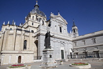 Spain, Madrid, Cathedral de la Almudena with statue of Pope John Paul II in the courtyard.