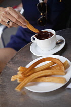 Spain, Madrid, Eating churros with hot chocolate.