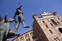 Spain, Madrid, Statue of a matador with the Plaza de Toros de las Ventas in the background.