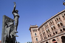 Spain, Madrid, Statue of a matador with the Plaza de Toros de las Ventas in the background.