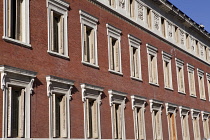 Spain, Madrid, Deatil of red coloured building facade with ornate shuttered windows.