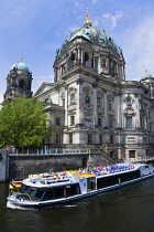 Germany, Berlin, Mitte, Museum Island. Berliner Dom, Berlin Cathedral with sightseeing tourists on a river cruise boat on the Spree.