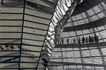 Germany, Berlin, Mitte, Tiergarten, interior of the glass dome on the top of the Reichstag building designed by architect Norman Foster with a double-helix spiral ramp around the mirrored cone that re...
