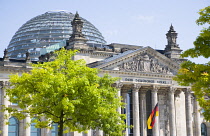 Germany, Berlin, Mitte, The Reichstag building in Tiergarten with the inscrption Dem Deucschen Volke, For the German People, on the facade above the columns at the entrance with Norman Foster's glass...