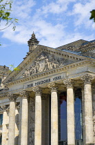 Germany, Berlin, Mitte, The Reichstag building in Tiergarten with the inscrption Dem Deucschen Volke, For the German People, on the facade above the columns at the entrance.