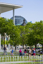 Germany, Berlin, Mitte, people cooling off in the water fountains in front of the Paul Loebe Haus by architect Stephan Braunfels housing the offices of the parliamentary committees of the Bundestag wi...