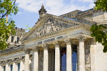 Germany, Berlin, Mitte, The Reichstag building in Tiergarten with the inscrption Dem Deucschen Volke, For the German People, on the facade above the columns at the entrance.