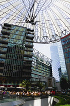 Germany, Berlin, Mitte, Potsdamer Platz, The Sony Centre designed by architect Helmut Jahn with the canopy over the central Forum of restaurants, offices, cinemas, shops and apartments with people eat...