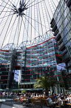 Germany, Berlin, Mitte, Potsdamer Platz, The Sony Centre designed by architect Helmut Jahn with the canopy over the central Forum of restaurants, offices, cinemas, shops and apartments with people eat...