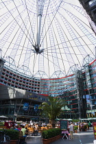 Germany, Berlin, Mitte, Potsdamer Platz, The Sony Centre designed by architect Helmut Jahn with the canopy over the central Forum of restaurants, offices, cinemas, shops and apartments with people eat...