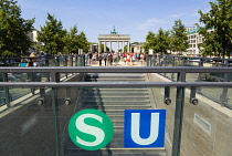 Germany, Berlin, Mitte, sightseeing tourists emerging from the U-Bahn and S-Bahn station on Unter den Linden and walking towards Brandenburg Gate or Bransenburger Tor.