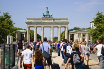 Germany, Berlin, Mitte, sightseeing tourists emerging from the U-Bahn and S-Bahn station on Unter den Linden and walking towards Brandenburg Gate or Bransenburger Tor.