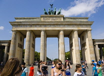 Germany, Berlin, Mitte, sightseeing young students at the Brandenburg Gate or Bransenburger Tor in Pariser Platz leading to Unter den Linden and the Royal Palaces with the Quadriga of Victory on top....