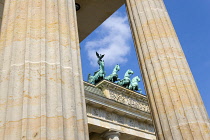 Germany, Berlin, Mitte, Brandenburg Gate or Bransenburger Tor seen between columns in Pariser Platz leading to Unter den Linden and the Royal Palaces with the Quadriga of Victory on top. The only rema...