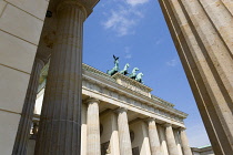 Germany, Berlin, Mitte, Brandenburg Gate or Bransenburger Tor seen between columns in Pariser Platz leading to Unter den Linden and the Royal Palaces with the Quadriga of Victory on top. The only rema...