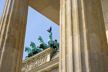 Germany, Berlin, Mitte, Brandenburg Gate or Bransenburger Tor seen between columns in Pariser Platz leading to Unter den Linden and the Royal Palaces with the Quadriga of Victory on top. The only rema...