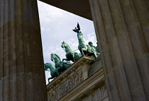 Germany, Berlin, Mitte, Brandenburg Gate or Bransenburger Tor seen between columns in Pariser Platz leading to Unter den Linden and the Royal Palaces with the Quadriga of Victory on top. The only rema...