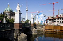 Germany, Berlin, Mitte, Museum Island with copper domed Berliner Dom, Berlin Cathedral, and tower cranes on construction sites beside the Spree River and the distant the Fernsehturm TV Tower.