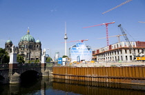 Germany, Berlin, Mitte, Museum Island with copper domed Berliner Dom, Berlin Cathedral, and tower cranes on construction sites beside the Spree River and the distant the Fernsehturm TV Tower.