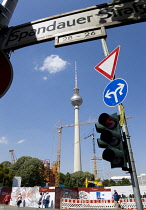 Germany, Berlin, Mitte, The Fernsehturm TV Tower with cranes working on reconstruction of the old eastern sector, roadsigns and traffic lights on Spandauer Strasse.