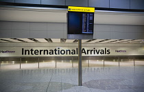England, London, Heathrow Airport, deserted International Arrivals hall with electronic arrivals board listing incoming due flights.