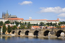 Czech Republic, Bohemia, Prague The Charles Bridge across the River Vltava with people walking across to the Little Quarter and Prague Castle with the Cathedral of Saint Vitus on the hill beyond.