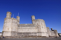 Wales, Gwynedd, Caernarfon Castle, Showing Eagle tower on the left, Queen's Tower and Chamberlain Tower against deep blue sky.