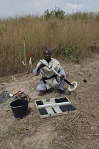Angola, Mine clearence specialist preparing equipment used to look for unexploded ordenance.