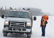 Canada, Alberta, Wabasca, Metis First Nation road flagger directing traffic related to oil and gas activities.