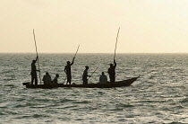 Tanzania, Zanzibar, Fishermen at dawn paddling out to go fishing, close to Paje.