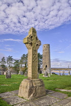 Ireland, County Offaly, Clonmacnoise Monastic Settlement, South Cross and Round Tower with River Shannon in the background.
