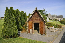 Ireland, County Mayo, Ballintubber Abbey, A replica of the first wooden church built in 441 AD when St. Patrick came to Ballintubber with the abbey in the background.