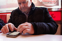 Communications, Telephone, Mobile, Man using Apple iPhone apps.