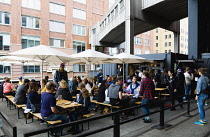 USA, New York, Manhattan, people seated at tables under umbrellas at an eating venue at the Chelsea Market Passage on the High Line linear park on a disused elevated railroad spur called the West Side...